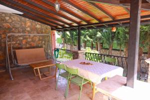 a patio with a table and chairs and a screen at Villa Oasis Taşın Zarafeti,Modern Rahatlık in Dalaman
