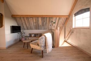 Camera mansardata con sedia e tavolo di B&B Country Suite Den Oord a Terwolde