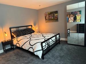 a bedroom with a large bed and a mirror at Apartment in the Heart of Buxton in Buxton
