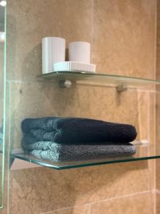 a glass shelf with towels on it in a shower at Apartment in the Heart of Buxton in Buxton