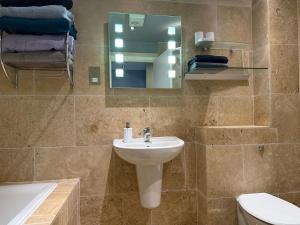 a bathroom with a sink and a toilet and a mirror at Apartment in the Heart of Buxton in Buxton +42 photos
