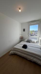 ein Schlafzimmer mit einem großen Bett mit einem großen Fenster in der Unterkunft Charme Citadin in Villemomble