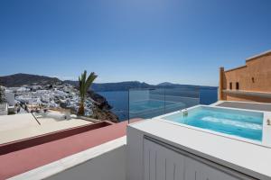 a villa with a swimming pool on the roof at ArmonOia Suites Santorini in Oia