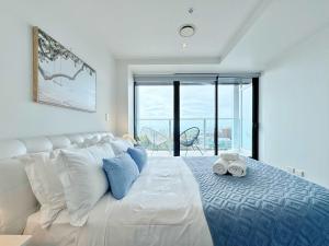 a white bed in a room with a large window at Amazing SeaView Central Stylish Near Aotea Square in Auckland