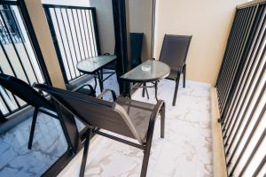 a balcony with three chairs and a table on a balcony at Fabulous Brand New 1BR, Gym Pool & Balcony in Ras al Khaimah