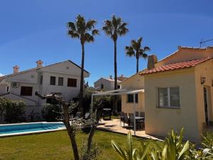 a house with palm trees and a swimming pool at Villa Tranquila in Alcossebre