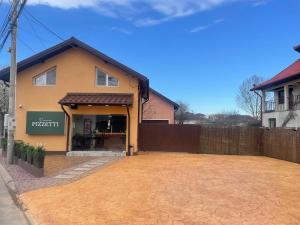 a yellow house with a fence in front of it at Studio ONE in Otopeni