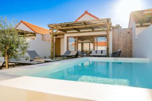 a swimming pool in front of a villa at Pestana Comporta Village Residences in Comporta