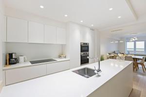 a kitchen with white cabinets and a white counter top at Evasion mer à Ostende in Ostend