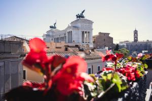a view of a city with red flowers in the foreground at Otivm Hotel in Rome