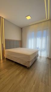 a bedroom with a large bed in front of a window at Luxor residence in Laguna