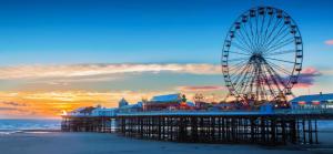 a ferris wheel on a pier on the beach at OYO Wave Crest Hotel in Blackpool