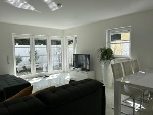 Una sala de estar con un sofá y un televisor. en Ferienwohnung Patricia, en Bad Neuenahr-Ahrweiler