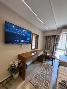 a living room with a large flat screen tv on the wall at Garden City Plaza Hotel in Cairo
