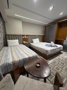 a hotel room with two beds and a table at Garden City Plaza Hotel in Cairo