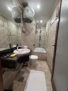 a bathroom with a sink and a toilet and a tub at Garden City Plaza Hotel in Cairo