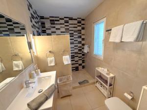 a bathroom with a sink and a tub and a toilet at Miramar3, Costa Calma, traumhafter Meerblick, max 2 Pers in Costa Calma +6 photos