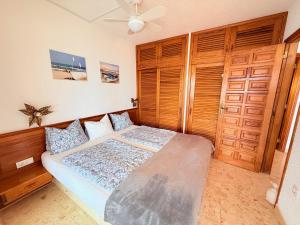 a bedroom with a bed and wooden doors at Miramar3, Costa Calma, traumhafter Meerblick, max 2 Pers in Costa Calma
