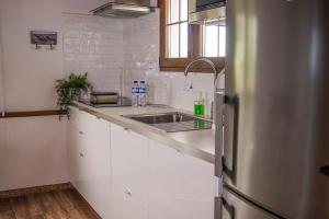 Una cocina con frigorífico de acero inoxidable y fregadero. en Vivienda Vacacional Finca Monterrey Mazo, en Mazo 71 fotos más