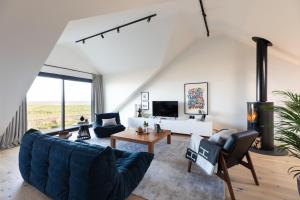 een woonkamer met een blauwe bank en een tafel bij Tide's Watch in Beadnell