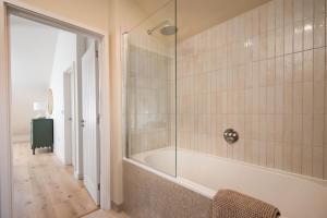 een badkamer met een bad en een glazen douche bij Tide's Watch in Beadnell +30 foto's