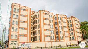 a building with a van parked in front of it at Elysian Homes Nakuru City in Nakuru