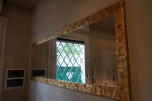 a mirror in a bathroom with a window at San Donato 40 in Bologna