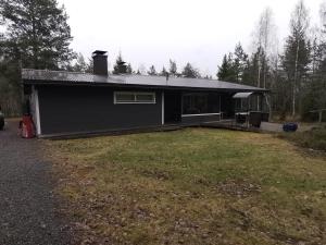 a black house with a yard in front of it at Talo Ristiinassa in Mikkeli