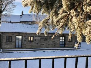 a stone house with snow in front of it at The Owl Stony Snug in Carstairs Junction