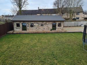 a stone house with a yard in front of it at The Owl Stony Snug in Carstairs Junction