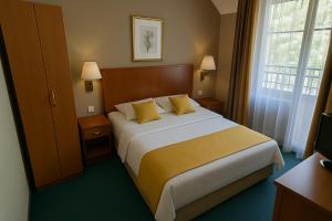 a hotel room with a large bed with yellow pillows at Resort Klewinowo in Klewinowo