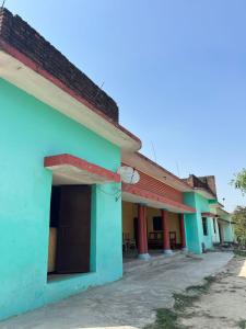 a row of houses with green and blue at Uday Homestay in Rāmpur