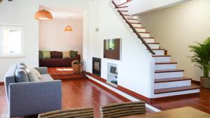 Una sala de estar con una escalera y un sofá. en Zéfiro Ericeira, en Ericeira