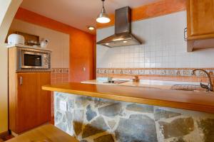 a kitchen with a counter with a sink and a microwave at Alojamiento Rural Benaocaz in Benaocaz