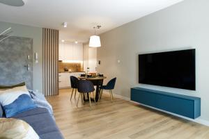 a living room with a large flat screen tv on a wall at Forest Apartment in Pobierowo
