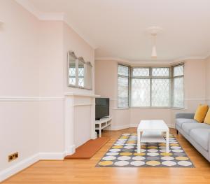 a living room with a couch and a table at Beautiful Bright Three Bedroom House in Brighton and Hove with free parking in Portslade