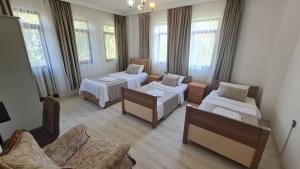 una camera con tre letti, un divano e finestre di The Tulip houses a Fethiye