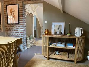 a room with a table and a shelf with items on it at La Maison du Cerisier - Chambre d'hôtes in Senlis