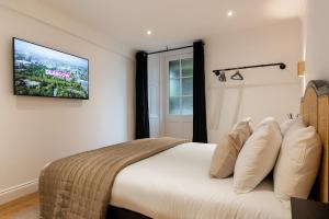 グラスゴーにあるStylish and Luxe 1 bed Apartment - Prime West Endの壁にテレビが付いたベッドのある寝室