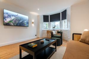 グラスゴーにあるStylish and Luxe 1 bed Apartment - Prime West Endのソファとテーブルのあるリビングルーム