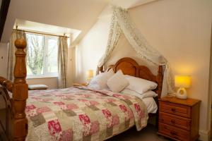 a bedroom with a large bed with a canopy at Cuckoo Springs Cottage Aberporth in Aberporth +10 photos