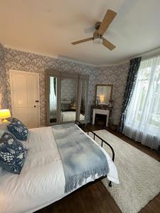 a bedroom with a bed and a ceiling fan at La Garde - Chambre D'hôte in Saint-Martin-de-Ribérac