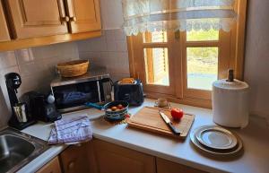 a kitchen counter with a cutting board and a microwave at Aether Beach House in Foiníkion +6 photos