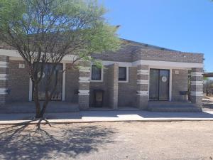 GhanziにあるGhanzi Travel and Accommodationの前に木があるレンガ造りの家