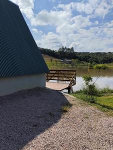 a picnic table sitting next to a body of water at Rancho dos lagos in Campo Alegre +2 photos