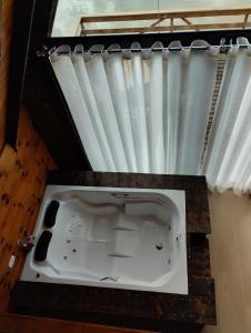 a bath tub in a room with a window at Rancho dos lagos in Campo Alegre