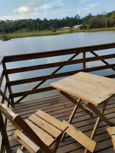 a picnic table and two chairs on a wooden deck at Rancho dos lagos in Campo Alegre