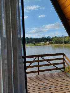 a view of a river from a porch with a window at Rancho dos lagos in Campo Alegre