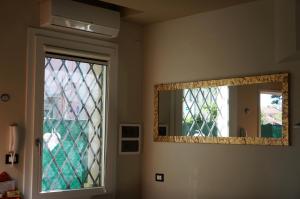 a bathroom with a mirror and a window at San Donato 40 in Bologna