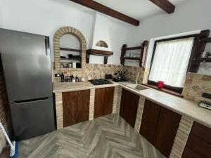 a kitchen with a stainless steel refrigerator and wooden cabinets at Hașca Chalet in Poiana Micului